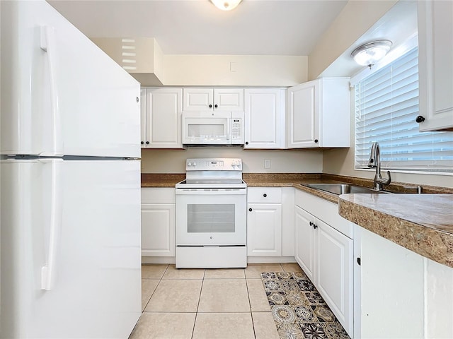 kitchen featuring white cabinets, light tile patterned floors, white appliances, and sink