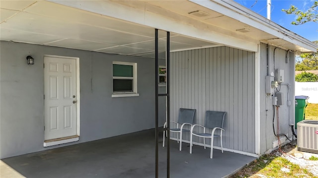 entrance to property featuring central air condition unit and a patio