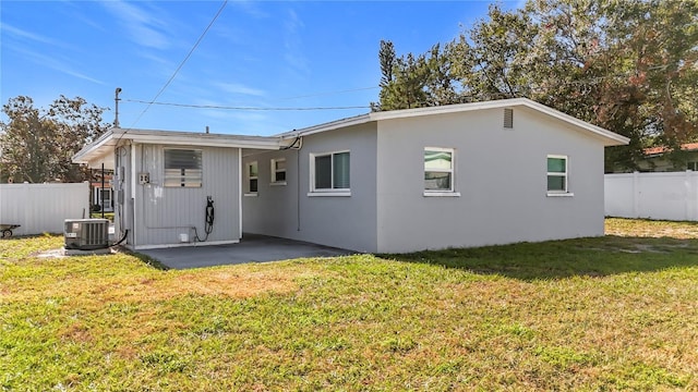 rear view of house featuring a lawn, a patio area, and central air condition unit