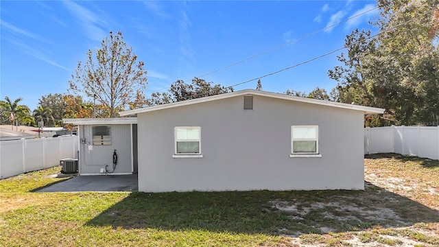 rear view of house with a patio area, a yard, and central air condition unit