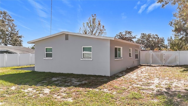 rear view of property featuring a lawn