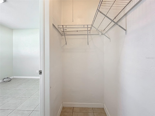 walk in closet with light tile patterned floors