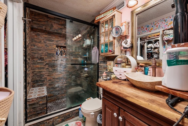 bathroom featuring vanity, a textured ceiling, toilet, and an enclosed shower