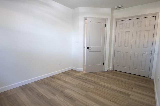 unfurnished bedroom featuring a closet and light wood-type flooring