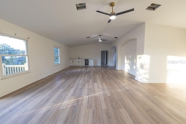 unfurnished living room featuring light hardwood / wood-style floors, vaulted ceiling, and ceiling fan