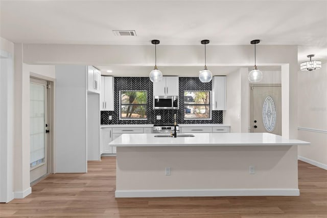 kitchen featuring decorative light fixtures, sink, and white cabinets