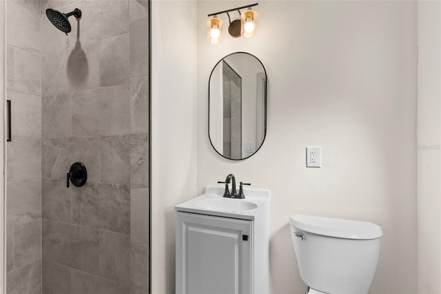 bathroom featuring vanity, toilet, and tiled shower