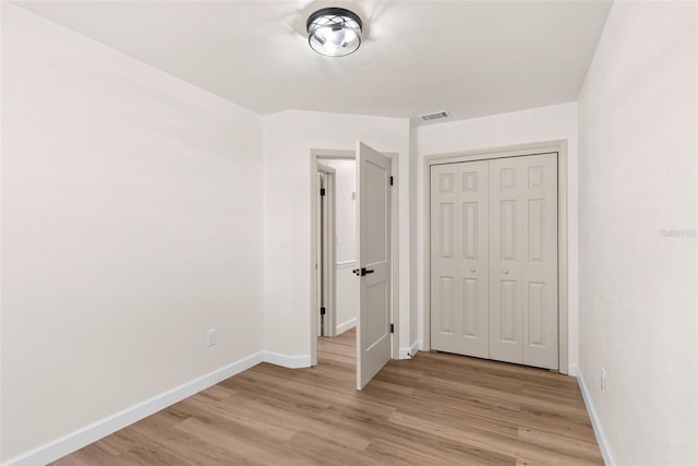 unfurnished bedroom featuring a closet and light wood-type flooring