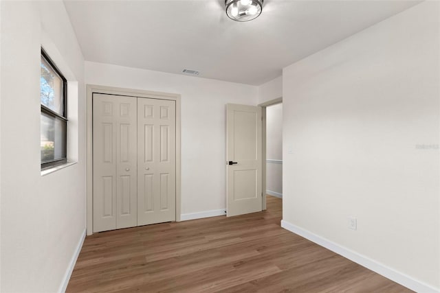 unfurnished bedroom with hardwood / wood-style flooring and a closet