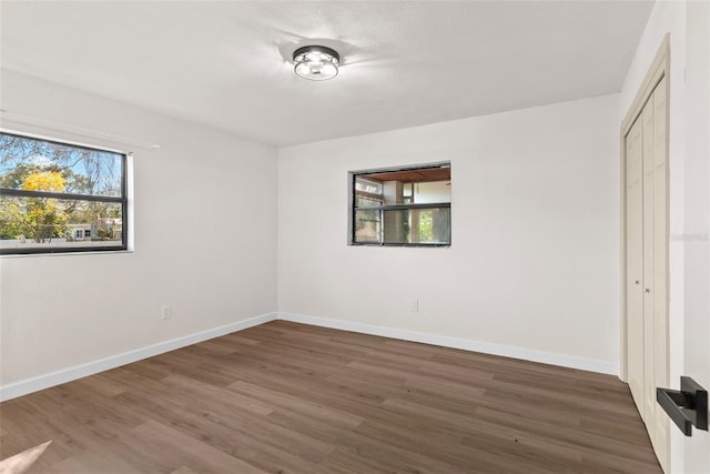 unfurnished bedroom featuring dark hardwood / wood-style flooring and a closet