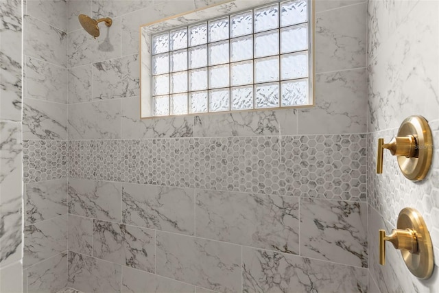 bathroom featuring plenty of natural light and tiled shower