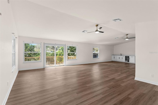 unfurnished living room with dark wood-type flooring, vaulted ceiling, and ceiling fan