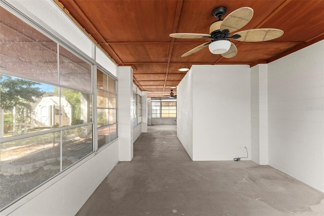 hallway with concrete flooring, plenty of natural light, and wooden ceiling