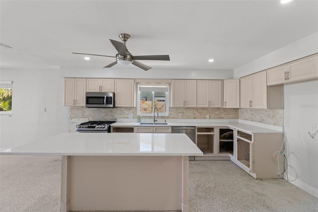 kitchen featuring backsplash, cream cabinets, sink, ceiling fan, and appliances with stainless steel finishes