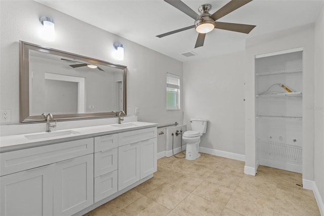 bathroom with tile patterned flooring, vanity, ceiling fan, and toilet