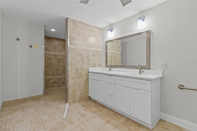 bathroom featuring tile patterned flooring, vanity, and tiled shower