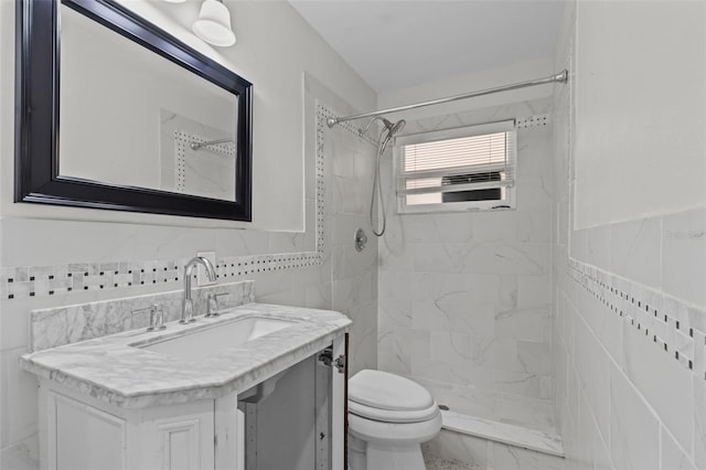 bathroom with toilet, vanity, tile walls, and tiled shower