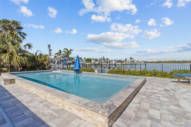 view of pool featuring a water view and a patio