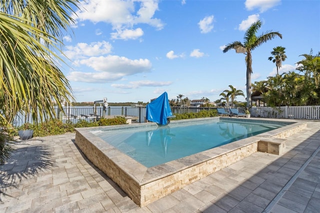 view of swimming pool with a patio area and a water view