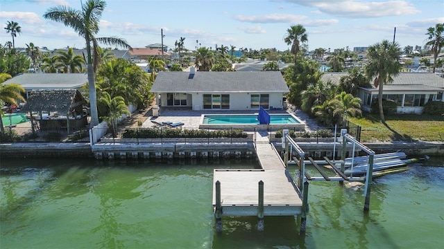 back of property with a water view and a patio