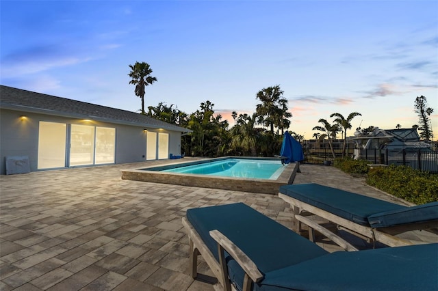 pool at dusk with a patio