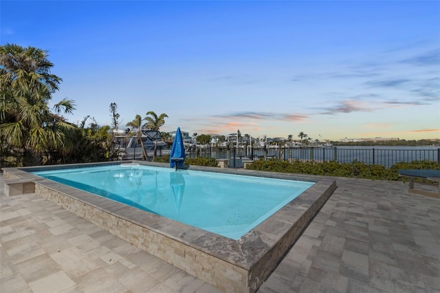 pool at dusk with a patio