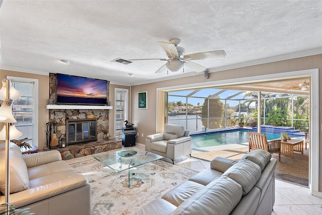 living room featuring a fireplace, crown molding, and plenty of natural light