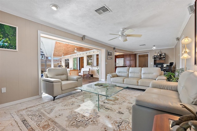 living room with ceiling fan, a healthy amount of sunlight, and a textured ceiling