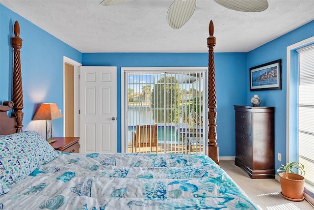 bedroom with access to exterior, light colored carpet, and a textured ceiling