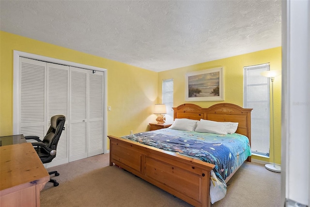 carpeted bedroom featuring a textured ceiling and a closet