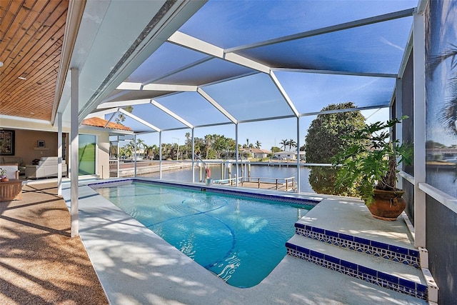 view of swimming pool with glass enclosure, a patio area, a water view, and a boat dock