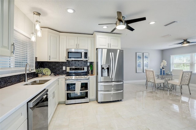 kitchen featuring white cabinets, decorative light fixtures, sink, and stainless steel appliances