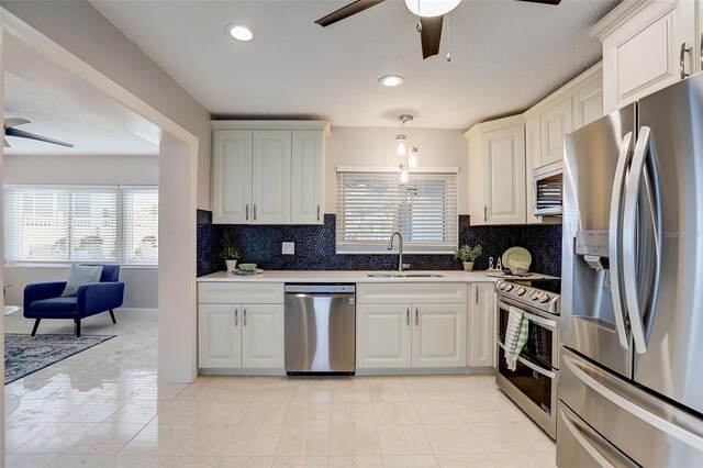 kitchen featuring decorative backsplash, appliances with stainless steel finishes, pendant lighting, and sink