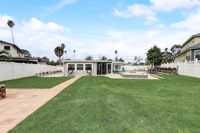 back of property with a sunroom, a patio area, and a lawn