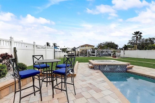 view of pool with a lawn, a patio area, and an in ground hot tub