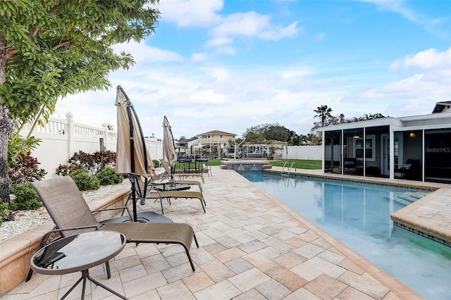 view of swimming pool with a patio and a sunroom