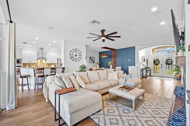 living room with french doors, light hardwood / wood-style flooring, and ceiling fan