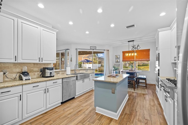 kitchen with white cabinets, light wood-type flooring, and stainless steel appliances