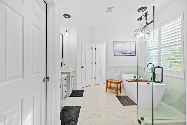 bathroom with a chandelier, vanity, tile patterned floors, and separate shower and tub