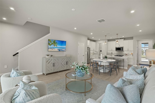 living room featuring light hardwood / wood-style floors and sink