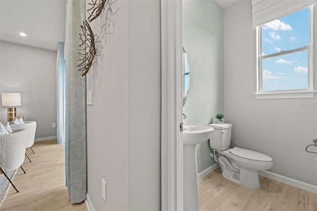 bathroom with hardwood / wood-style flooring and toilet