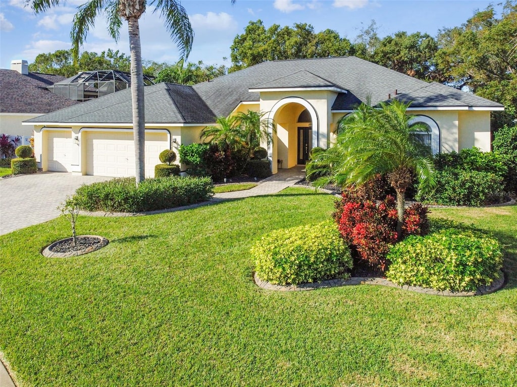 ranch-style home featuring a garage and a front lawn