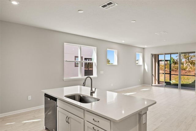 kitchen with sink, white cabinetry, dishwasher, a kitchen island with sink, and light hardwood / wood-style floors