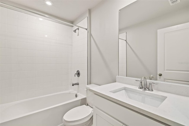 full bathroom with tiled shower / bath, vanity, and toilet