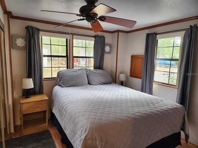 bedroom featuring ceiling fan, dark hardwood / wood-style flooring, a textured ceiling, and ornamental molding