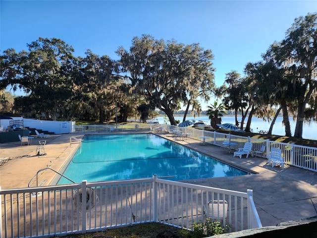 view of pool featuring a water view and a patio area