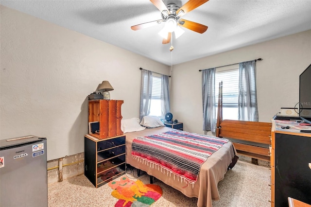 carpeted bedroom featuring a textured ceiling and ceiling fan