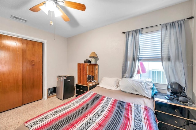 bedroom with stainless steel fridge, ceiling fan, a closet, and carpet floors