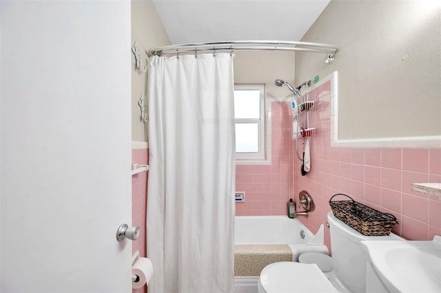 full bathroom featuring toilet, tile walls, shower / bath combo with shower curtain, and sink