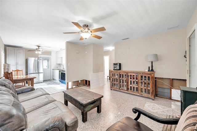 living room with ceiling fan and sink